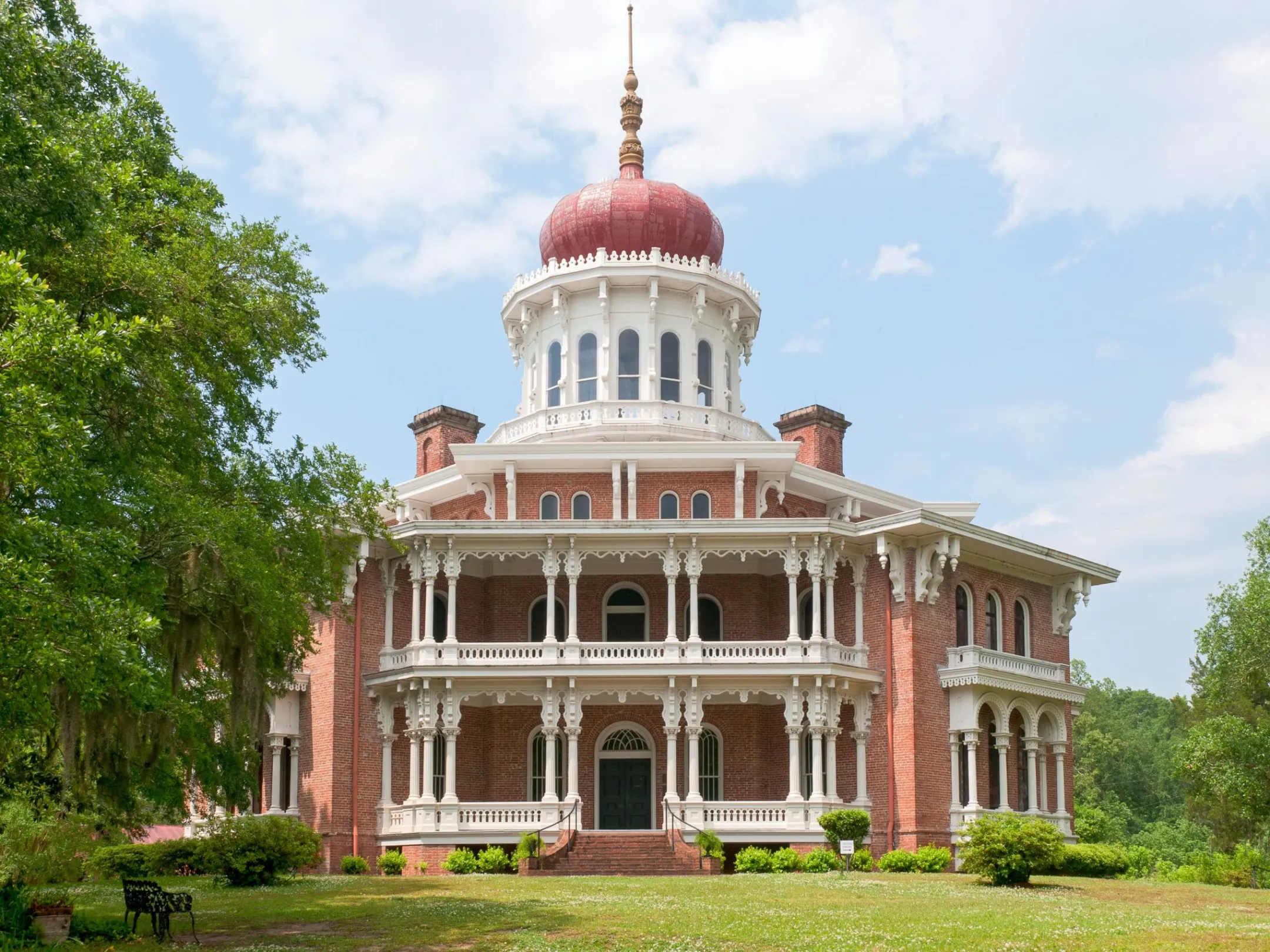 a large brick building with grass and trees