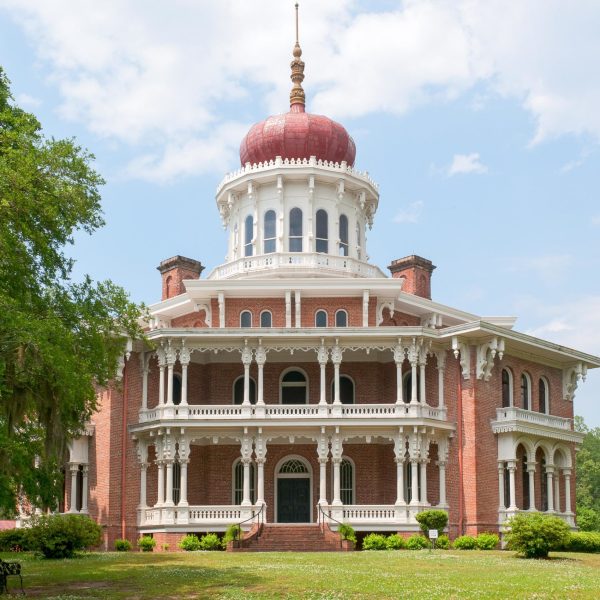 a large brick building with grass and trees