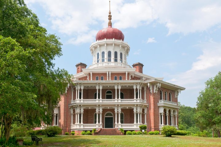 a large brick building with grass and trees