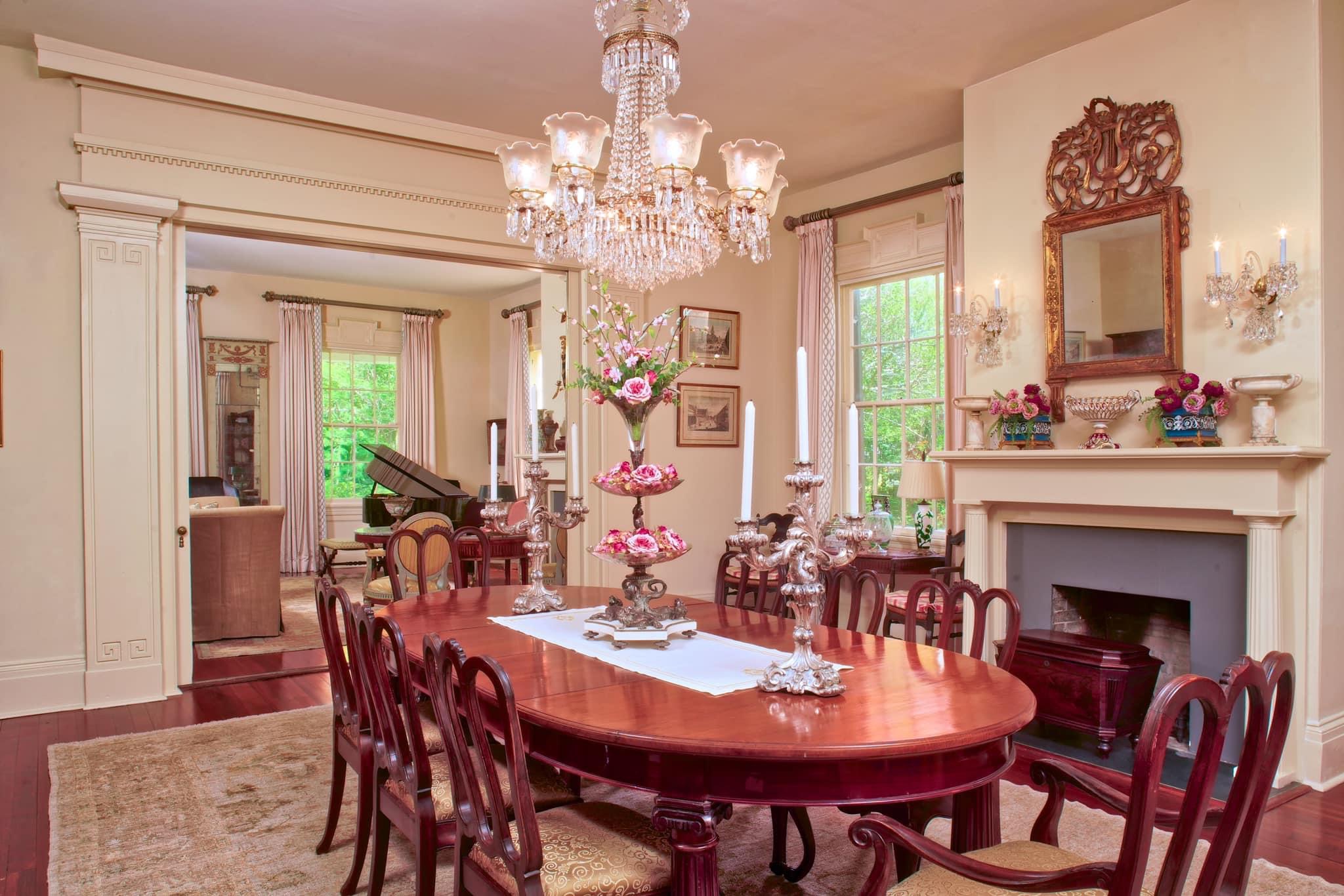 a dining room filled with furniture and vase of flowers on a table