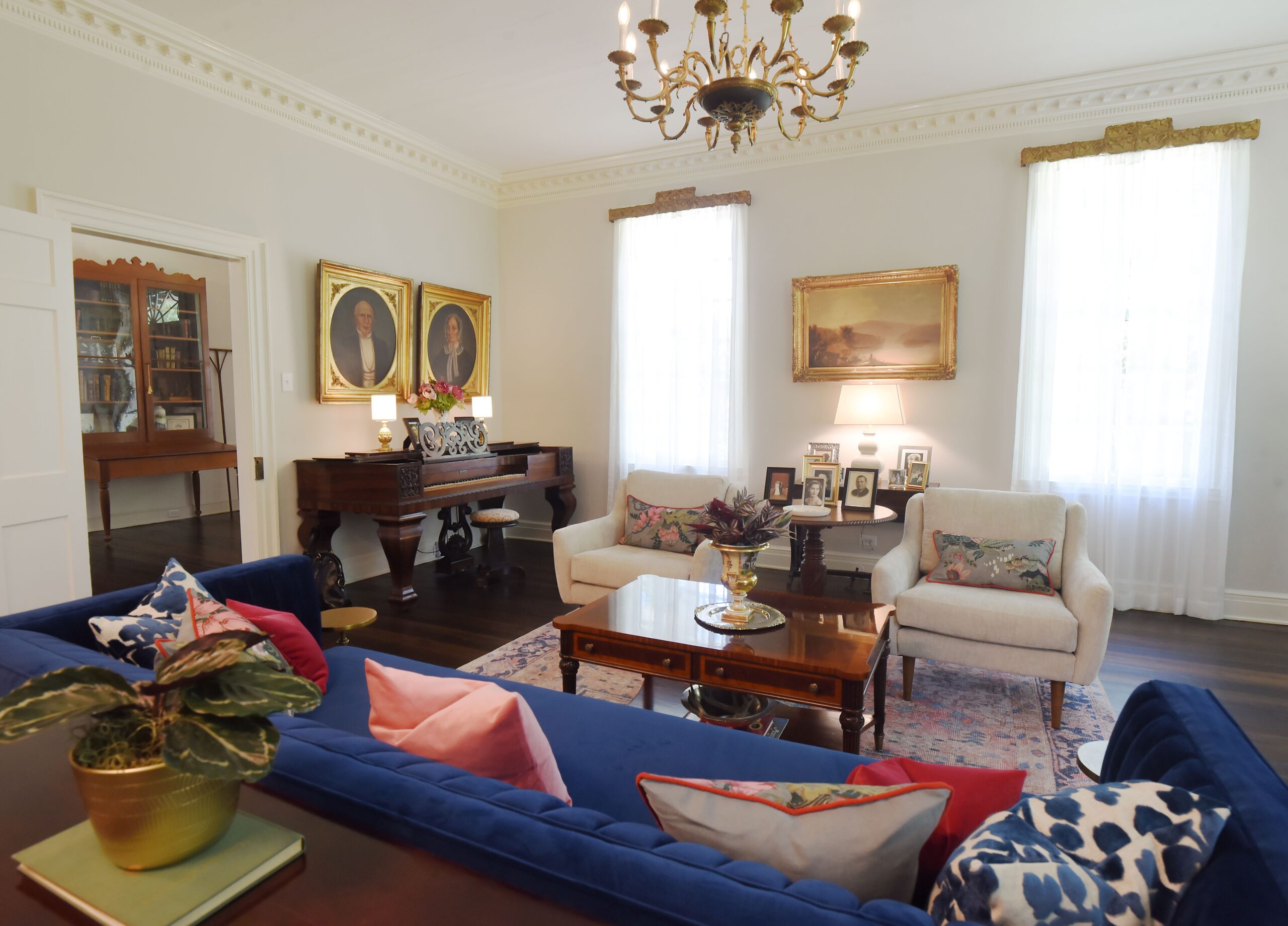 a living room filled with furniture and vase of flowers on a table