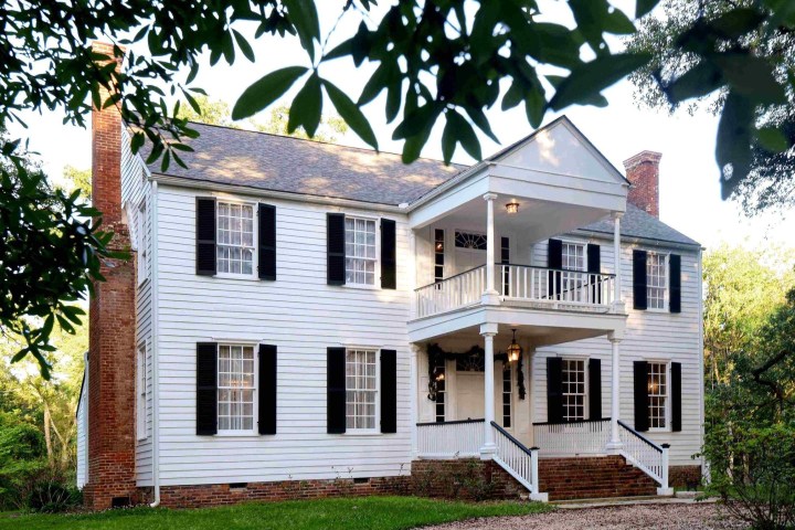 a large brick building with grass in front of a house