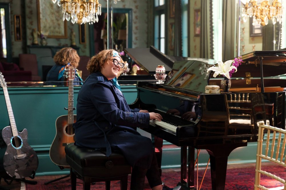 a person sitting at a table in front of a piano