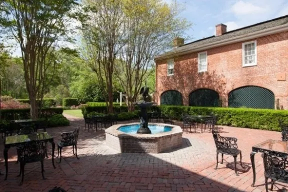 an empty park bench next to a brick building
