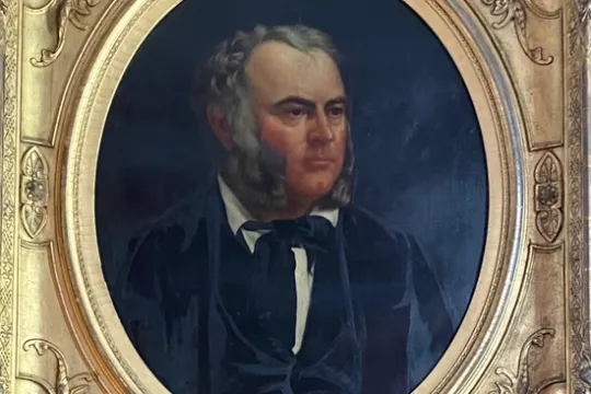 Oval portrait of a man with sideburns in ornate gold frame.