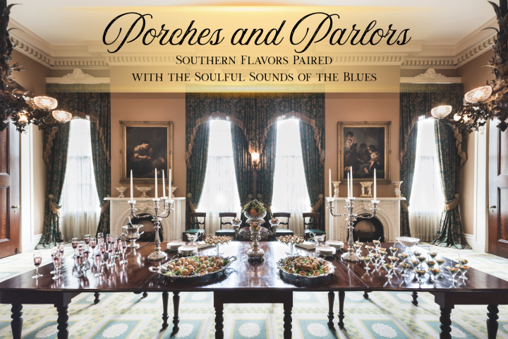 Elegant dining room with a long table set for an event, featuring chandeliers and large windows.